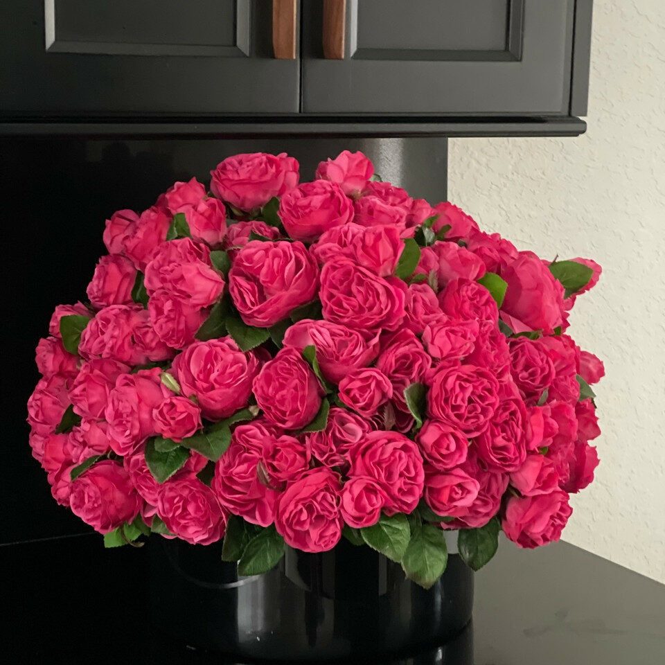 Roses anglaises rose foncé dans un vase en verre rouge