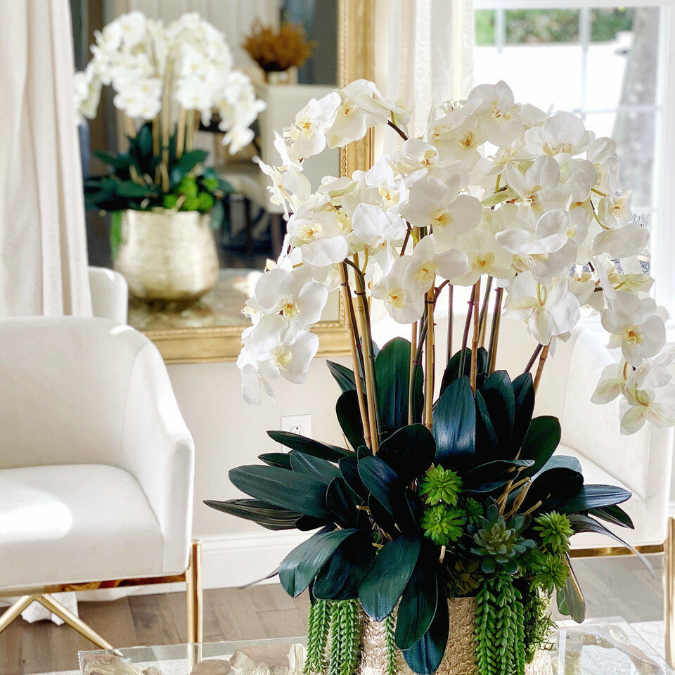 Jarrón dorado Delaney con múltiples tallos de orquídeas Phalaenopsis y suculentas