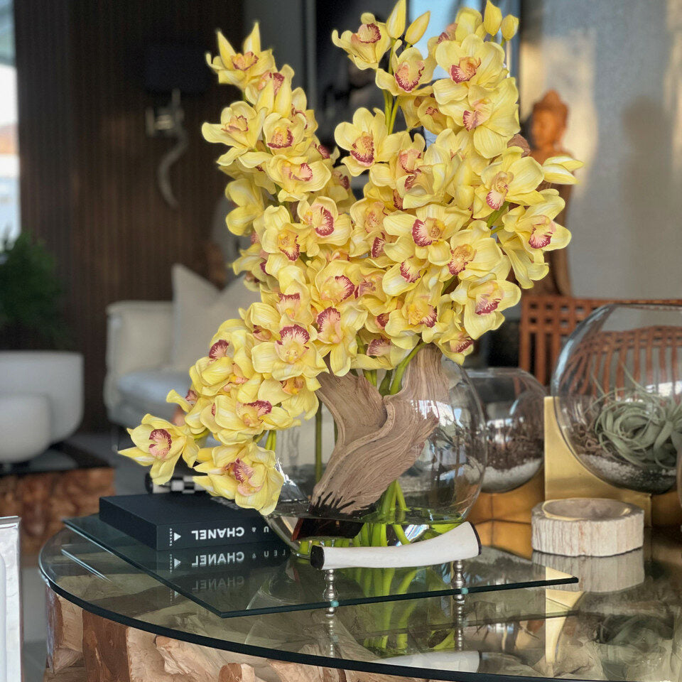 Cymbidiums amarillos en un jarrón lunar