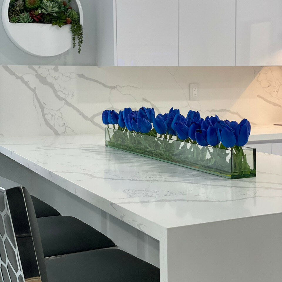 Jarrón de cristal moderno con tulipanes azules.
