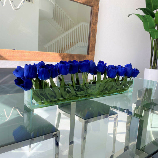 Jarrón de cristal moderno con tulipanes azules.