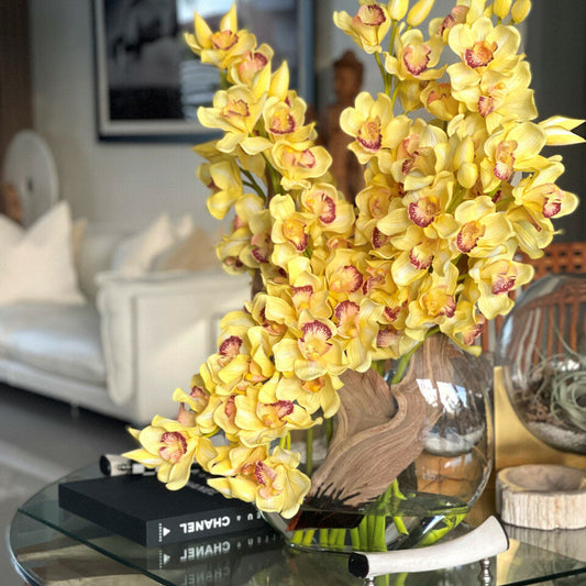 Cymbidiums amarillos en un jarrón lunar