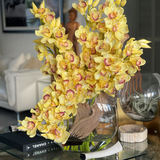 Cymbidiums amarillos en un jarrón lunar
