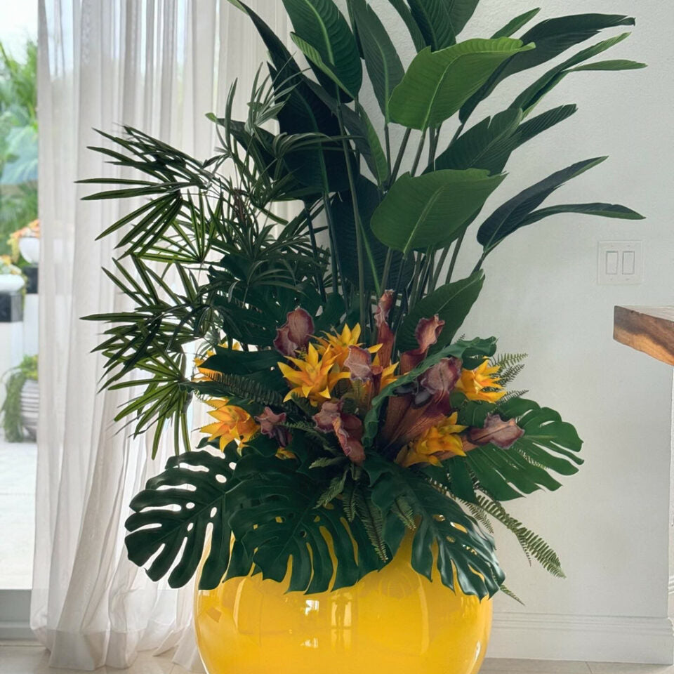 Mélange de plantes tropicales dans un verre ballon jaune
